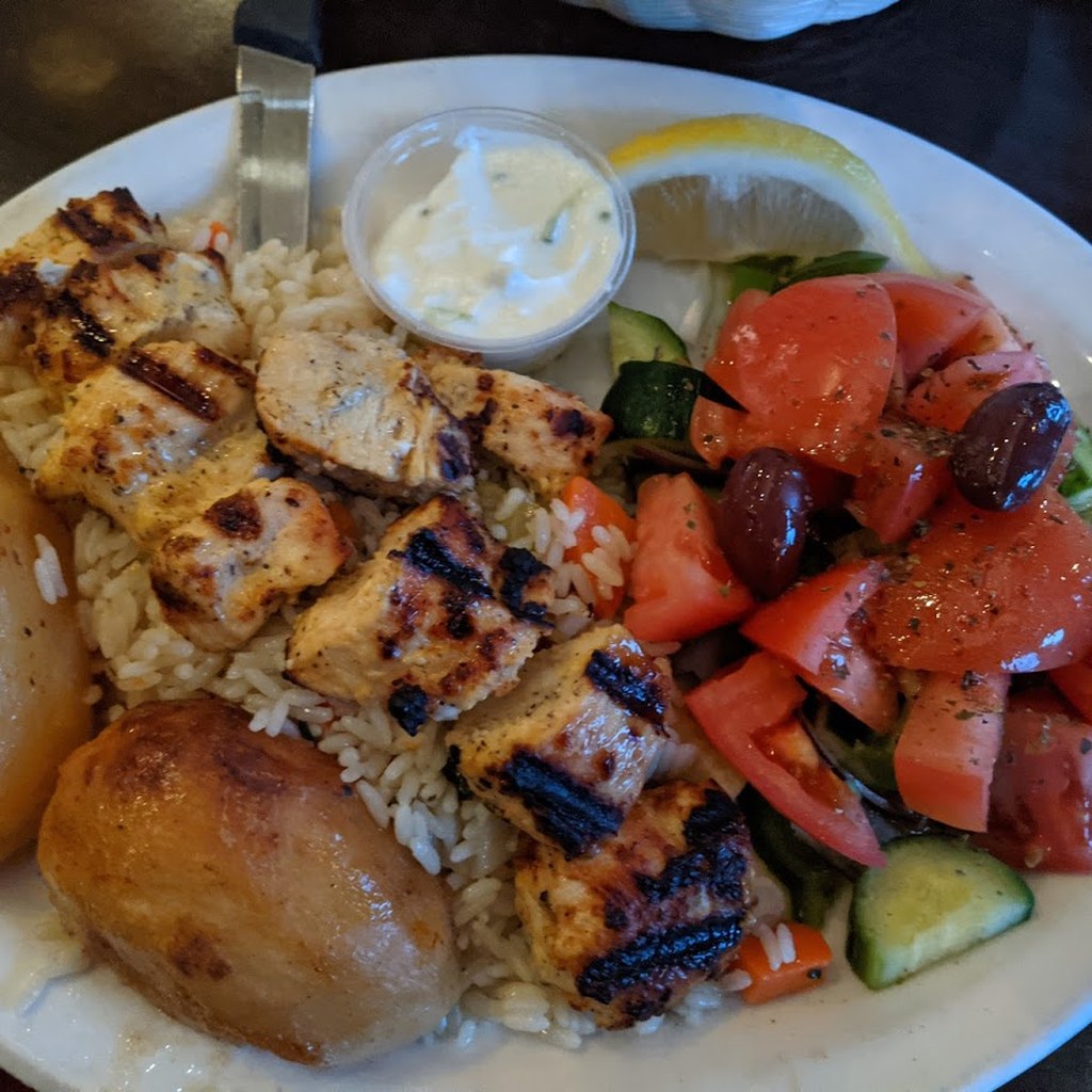Chicken souvlaki plate with Greek salad, roasted potato, rice, tzatziki, and lemon at Olympia Pizza on Denman Street